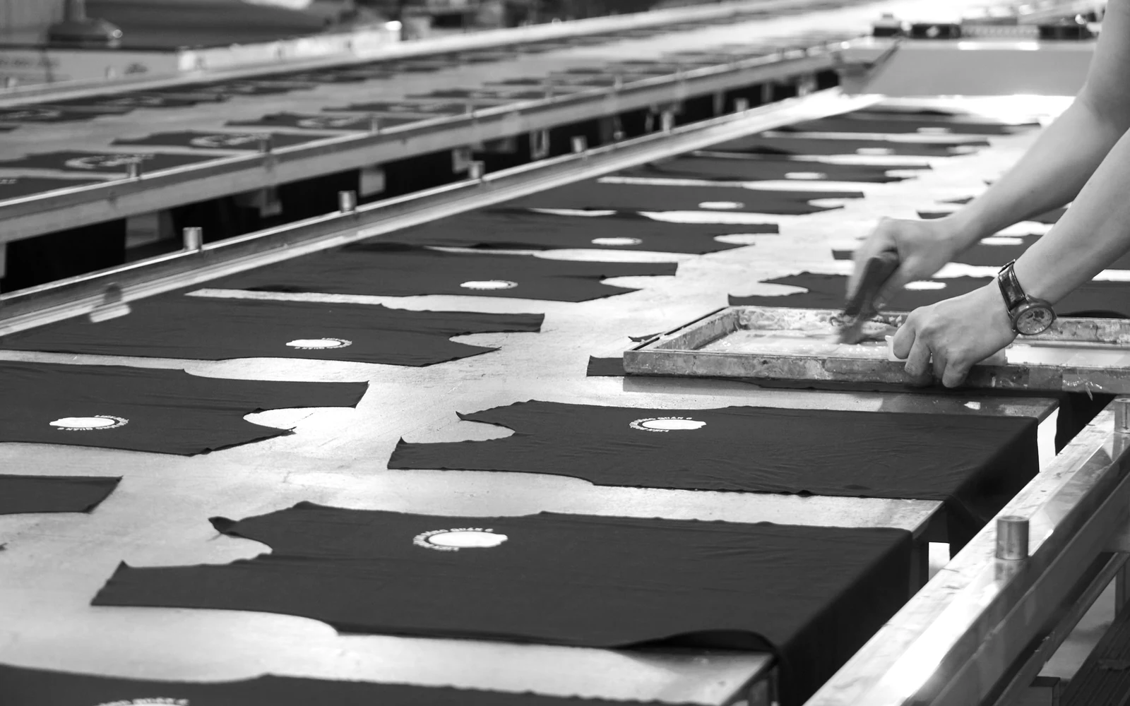 a person cutting fabric on a conveyor belt. Photograph accompanying Velaharra’s creative community participation guide.