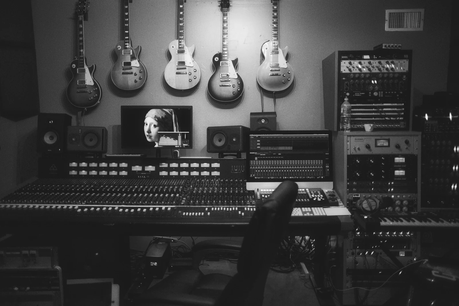 A music recording studio with guitars on the wall and a large mixing console. Photograph accompanying Velaharra’s artist representation vs artist advisory guide.